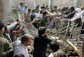 One killed, many feared trapped in building collapse